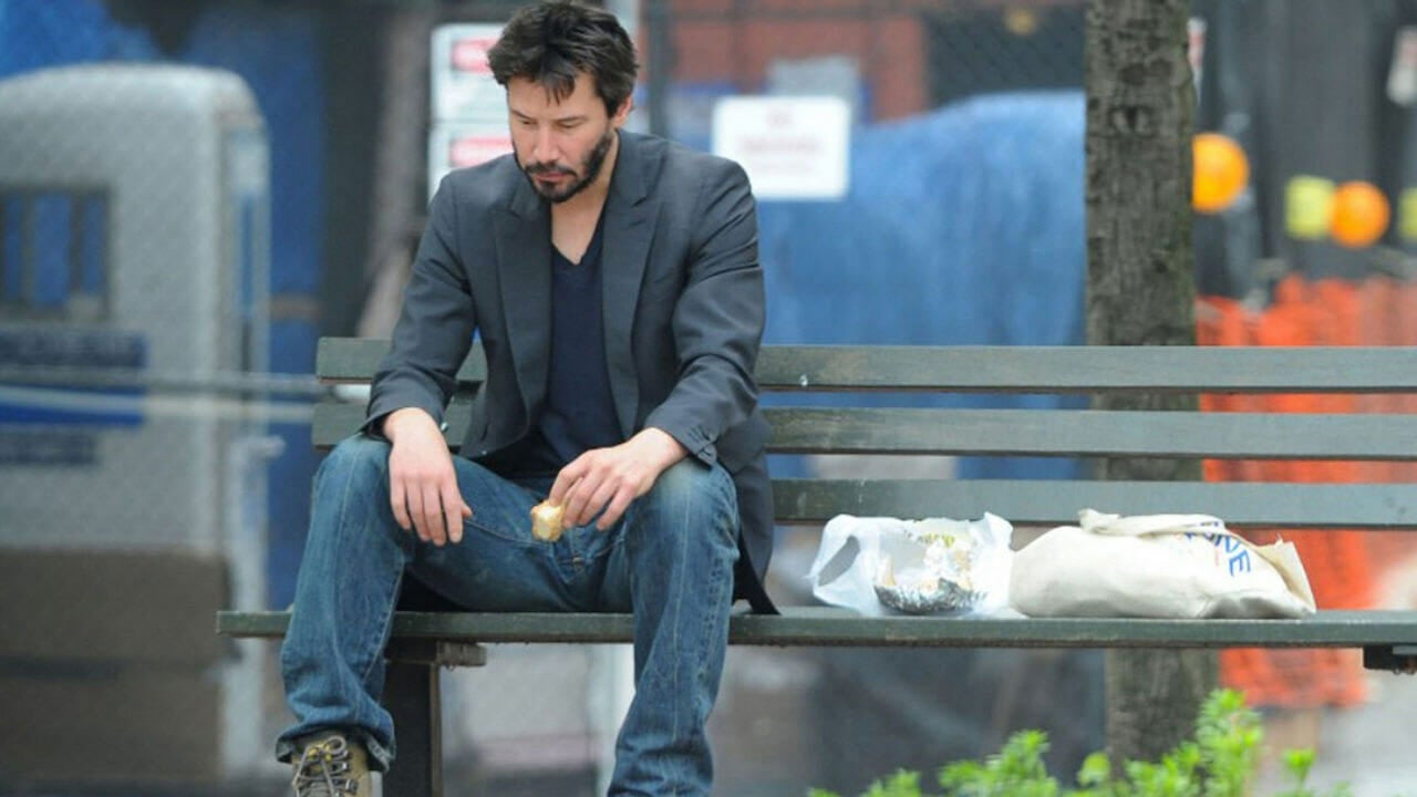Sad Keanu Reeves Sitting On A Bench