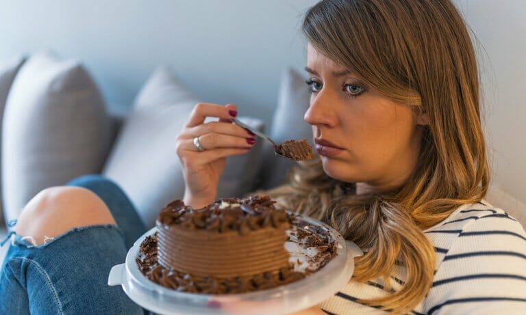 woman eating cake distressed 768 1