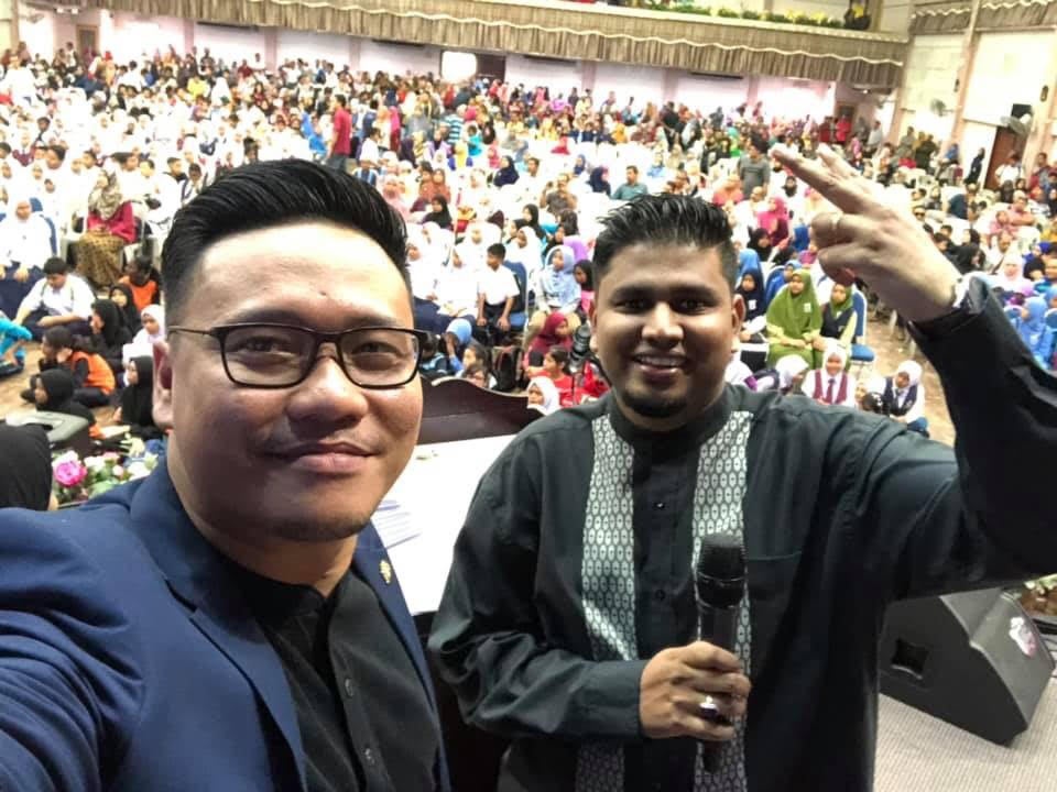 Cikgu Lan (pictured right) with his students behind him.