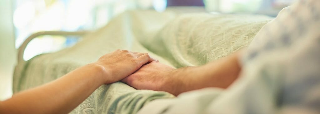 Hospital Bedside Holding A Patient'S Hand To Give Support