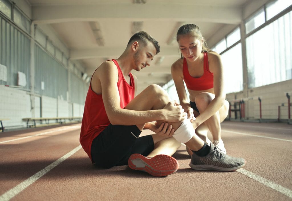 Woman Helping Sportsman With Injury During Cardio Training 3760275 E1592566468609