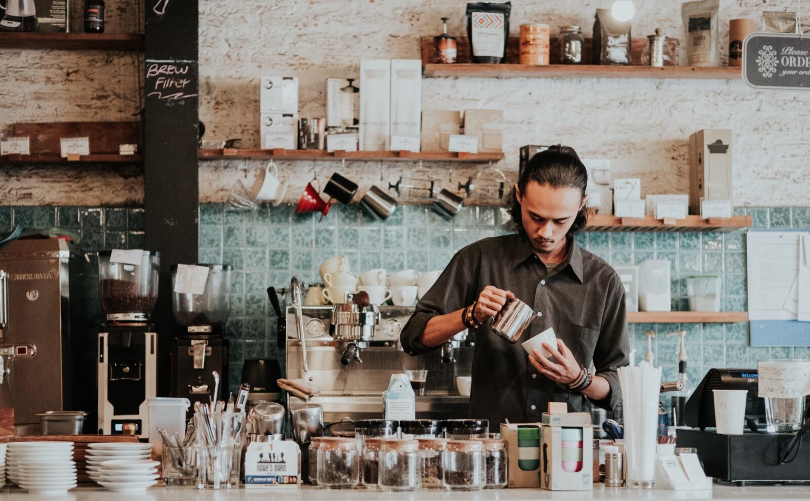 A local man pouring coffee as a barista