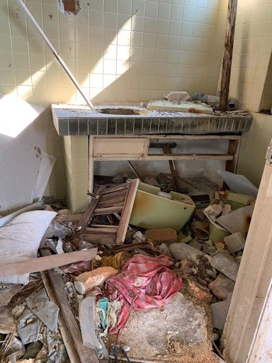 The looters would remove the toilet seats and wall portions to uncover and strip away the metals, and then dump the leftover broken ceramics and bricks in the kitchen.