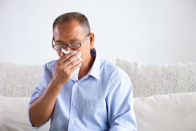 sick asian old man using tissue paper close mouth while cough 53476 4981