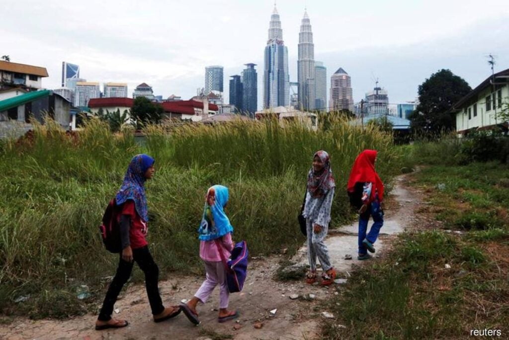 girls and children living in Malaysian urban poverty within sight of the Petronas Twin Towers