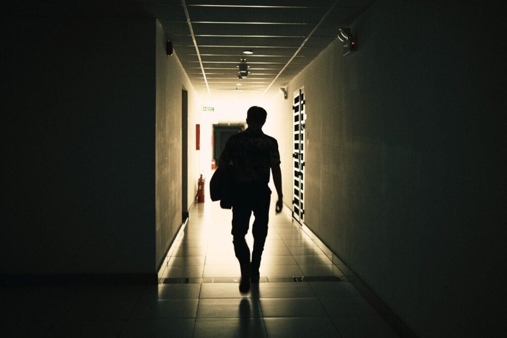 Silhoutte Of A Person Walking Down Corridor