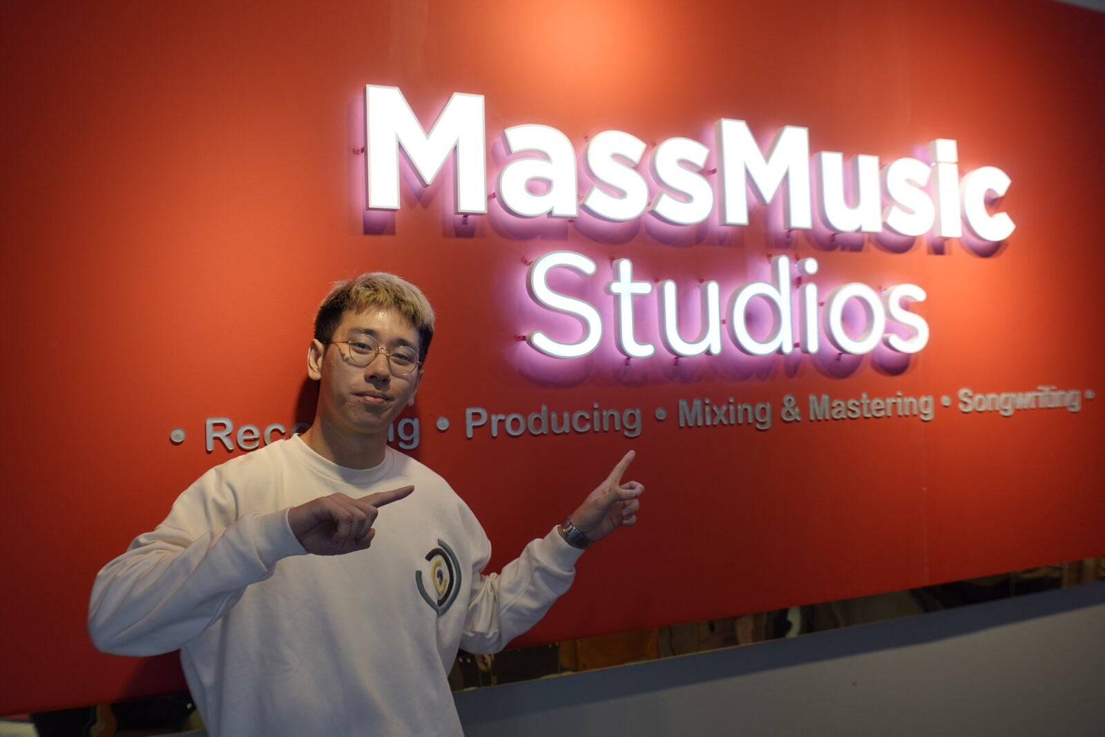 Yue Wai Ming posing in front of their logo at MassMusic Studios in Petaling Jaya, Selangor.