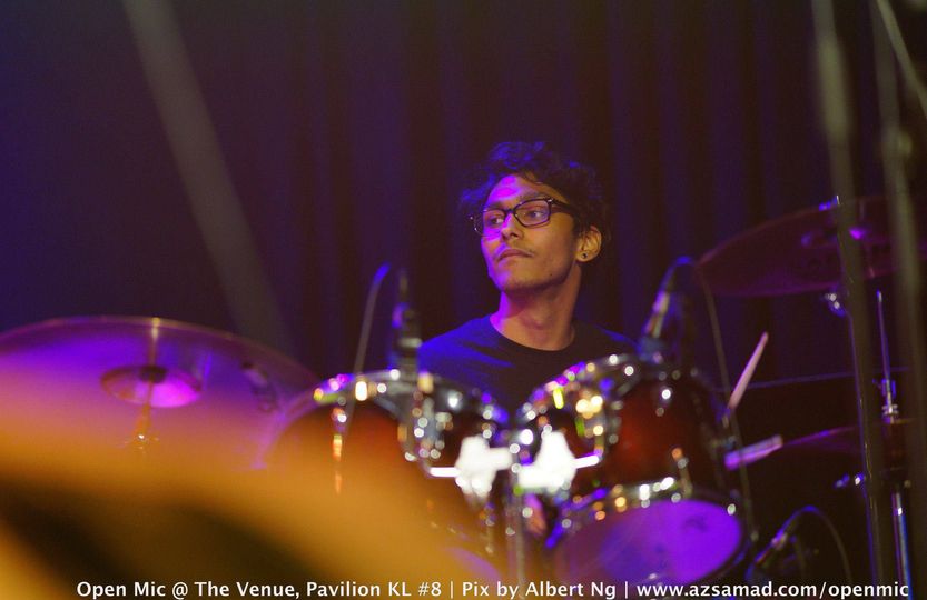 A young Malaysian Indian man playing the drums at an open mic event at The Venue, Pavillion KL.
