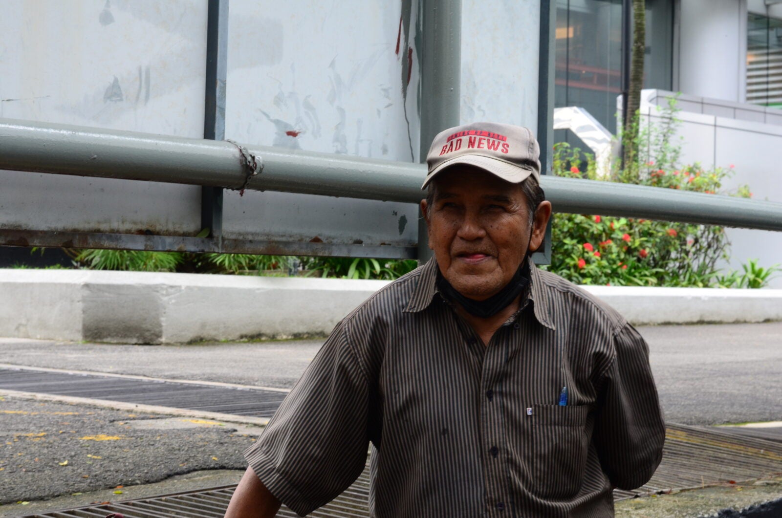 A shoe cobbler wearing a cap and standing at the WISMA MCA, Kuala Lumpur.