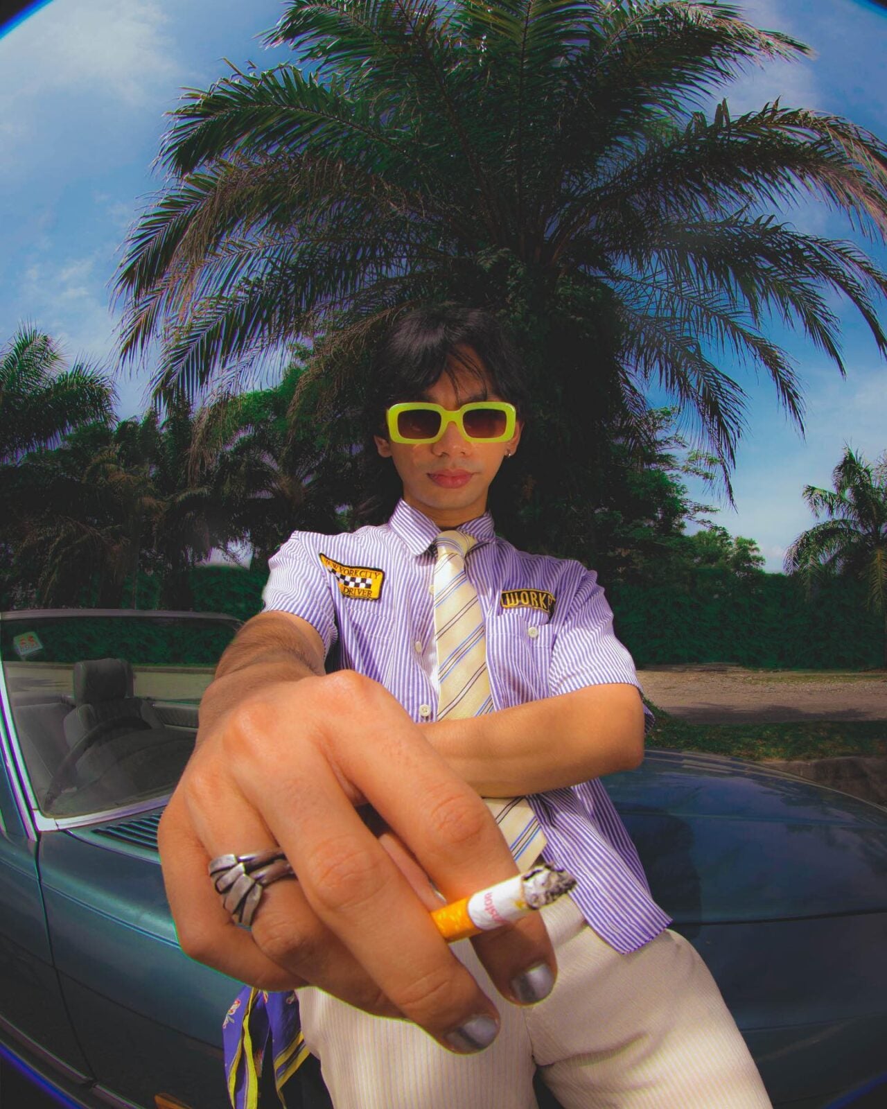 Muaz Rabbani wearing yellow sunglasses and posing with a cigarette in his hand for the album pictures of his band, Midnight Fusic.