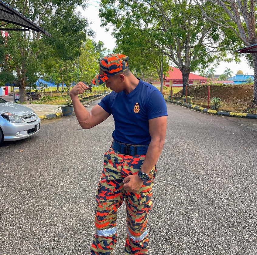 A Malaysian fire fighter poses and flexes his biceps.