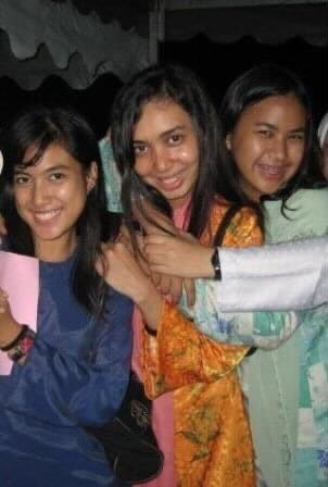 Three Malay girls posing in the baju kurung.