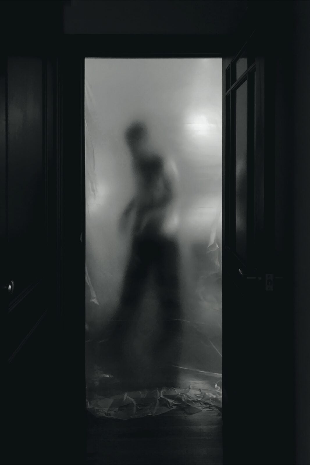 A ghostly sillhoutte of a man walking in a room.