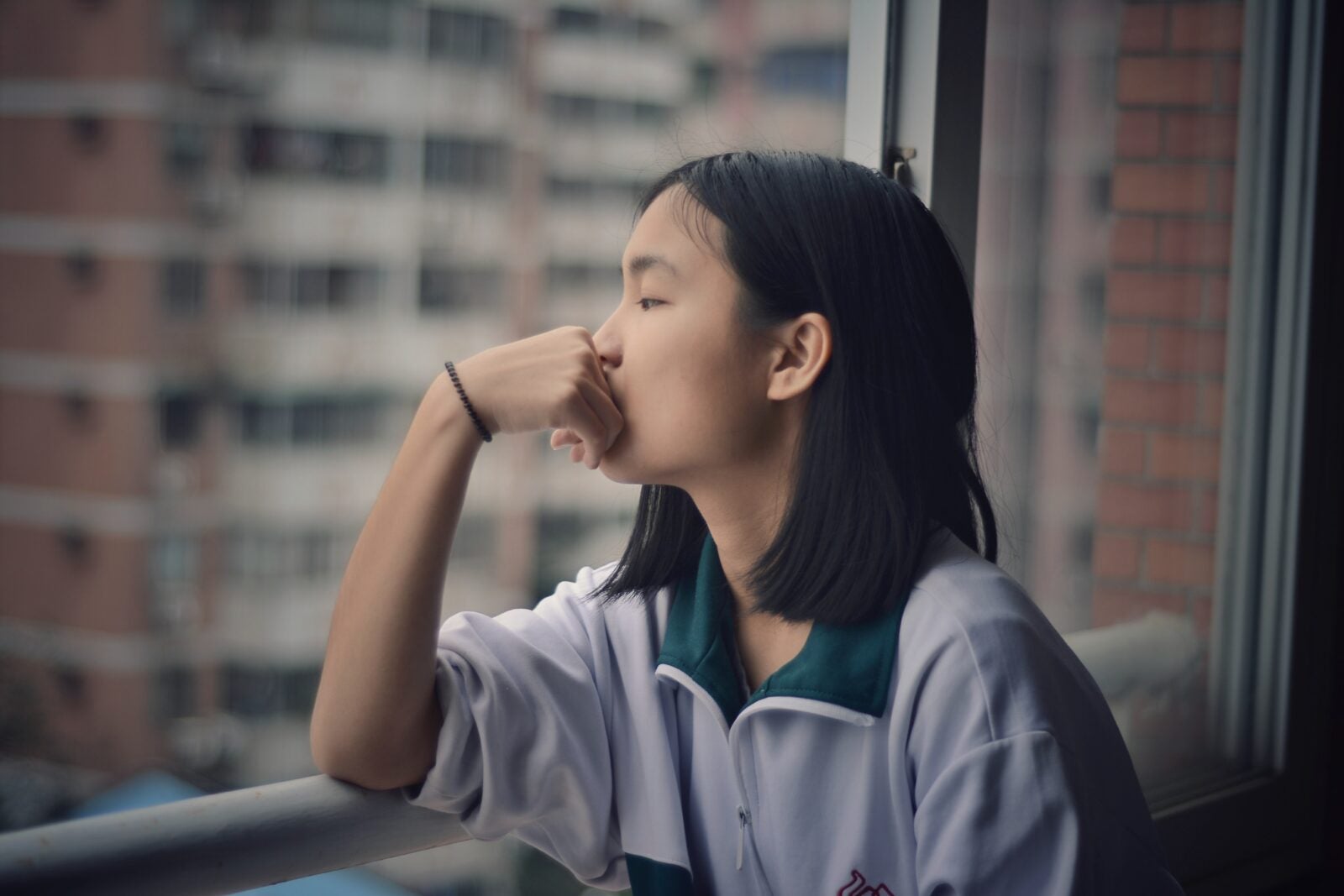 Young Asian girl looking out the window.