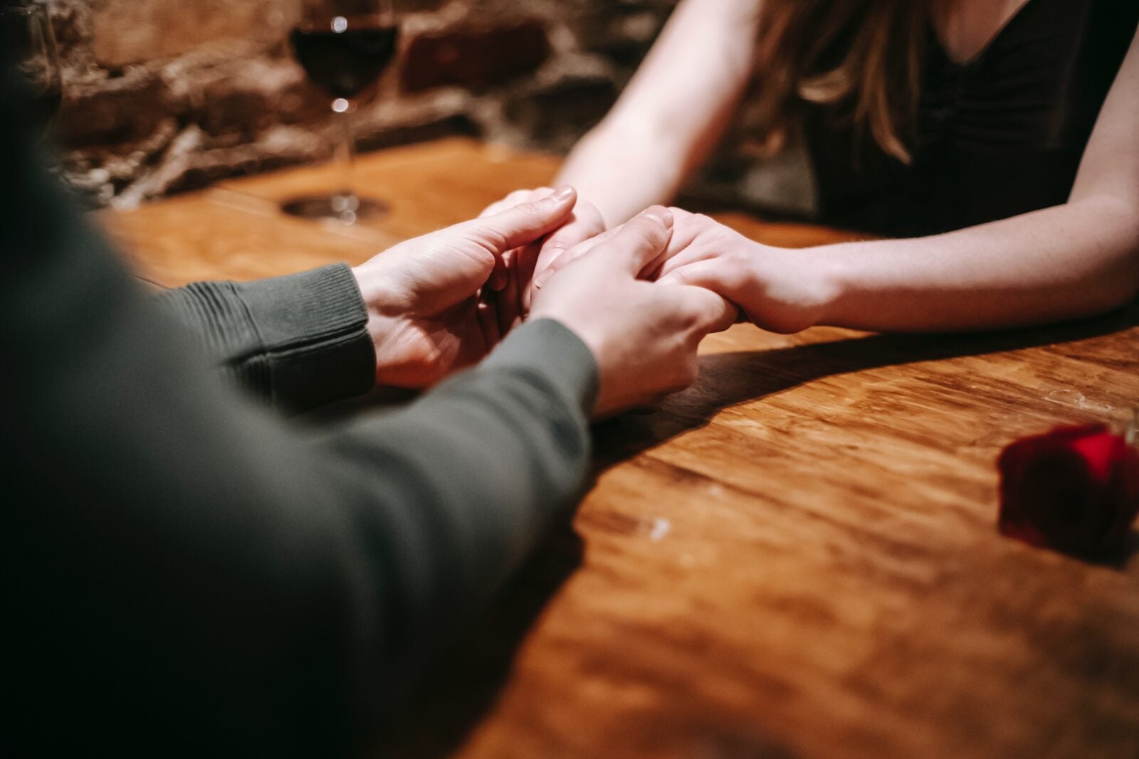 A couple holding hands while sitting at a table.