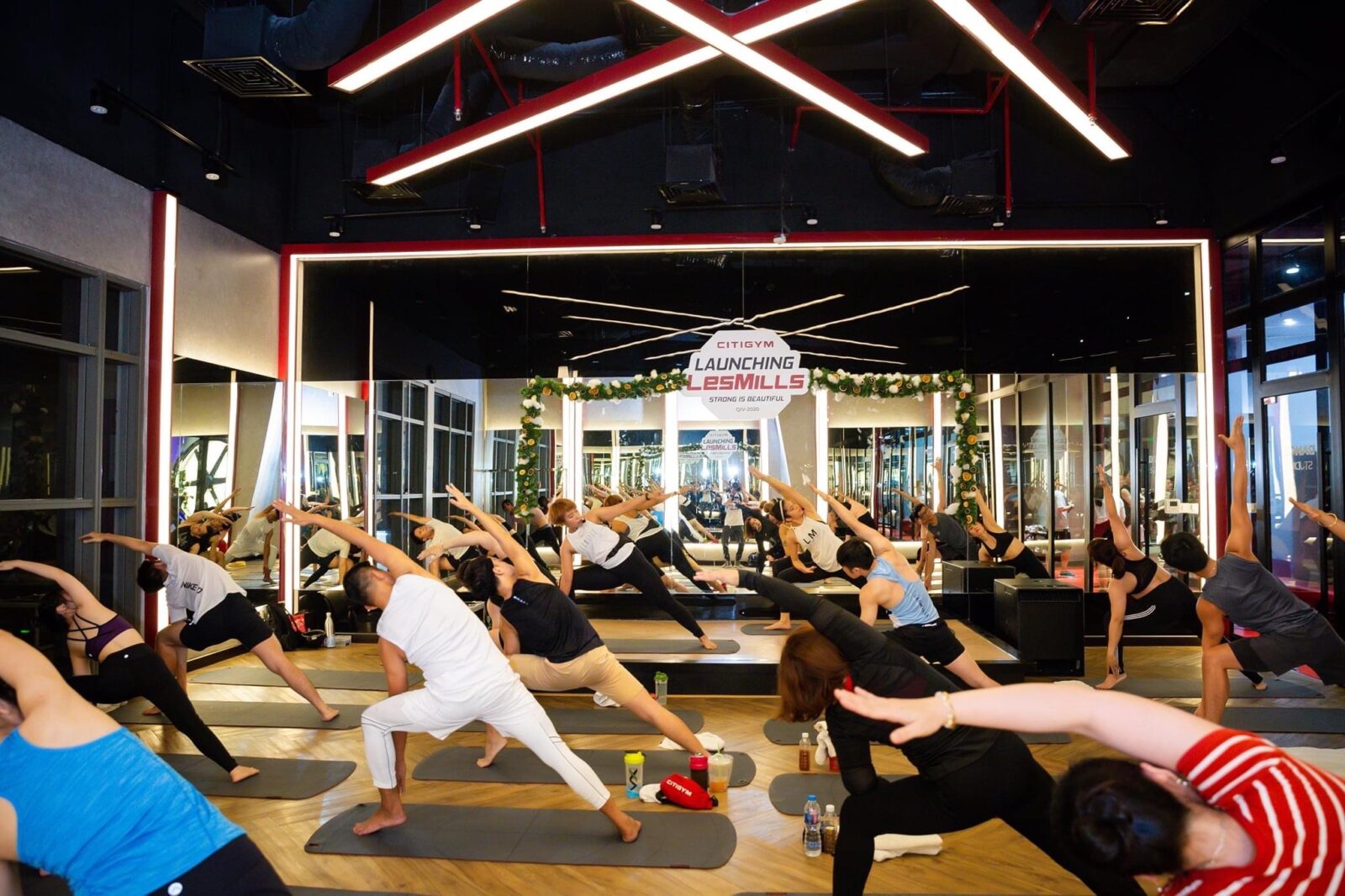 A room full of people who are stretching in their yoga attire at Les Mills Studio in Kuala Lumpur, Malaysia