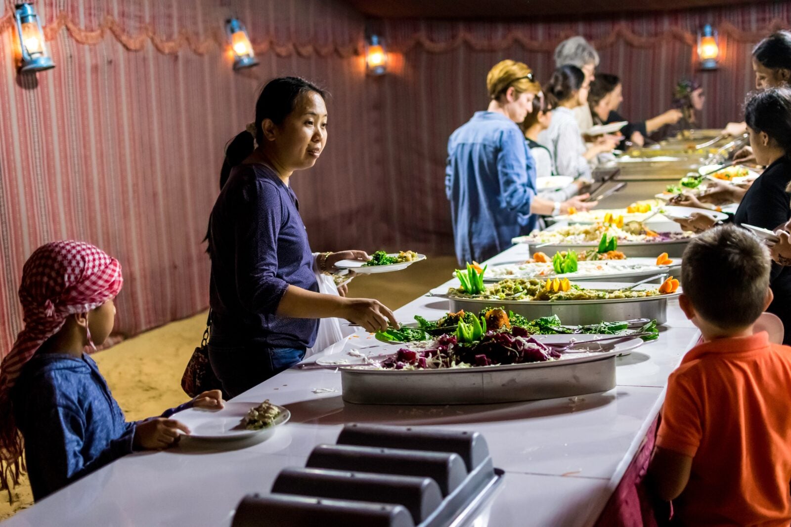 A Group of People Getting Food on Buffet Table