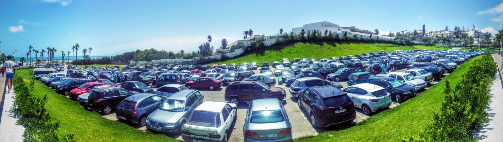 Panoramic view of long stretches of parked cars.
