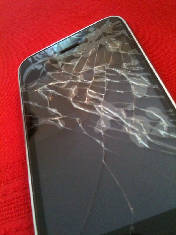 Image shows a phone with the top part of its screen filled with cracks. 