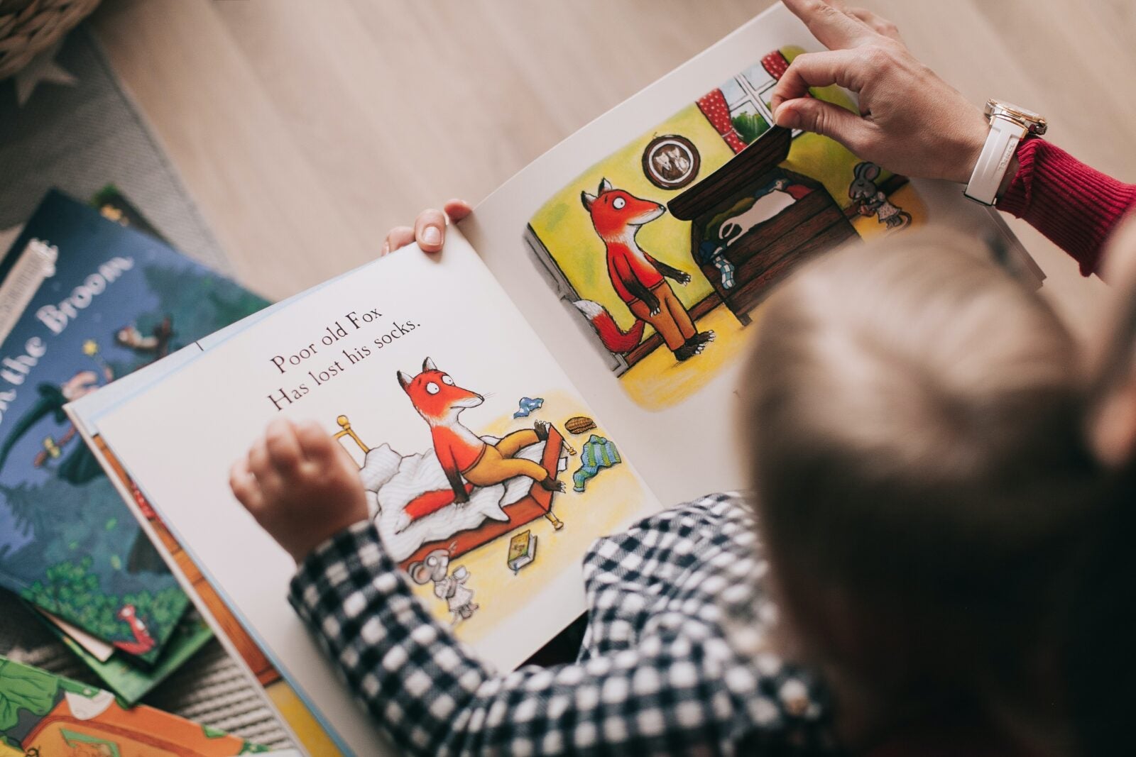 A child reads a children's book that has a fox on it.