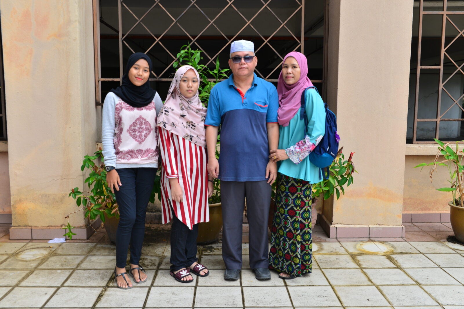 A Malay Malaysian family posing side by side with each other. 