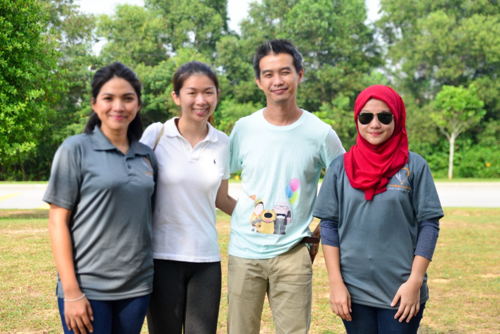 A Chinese Couple Posing Between Two Malay Women.. One Of The Malay Women Is Wearing Sunglasses And Red Hijab.