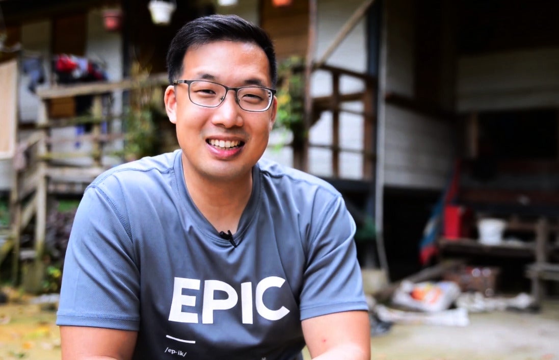 CEO of EPIC, John Son-Oei being interviewed in front of a home that his project built.