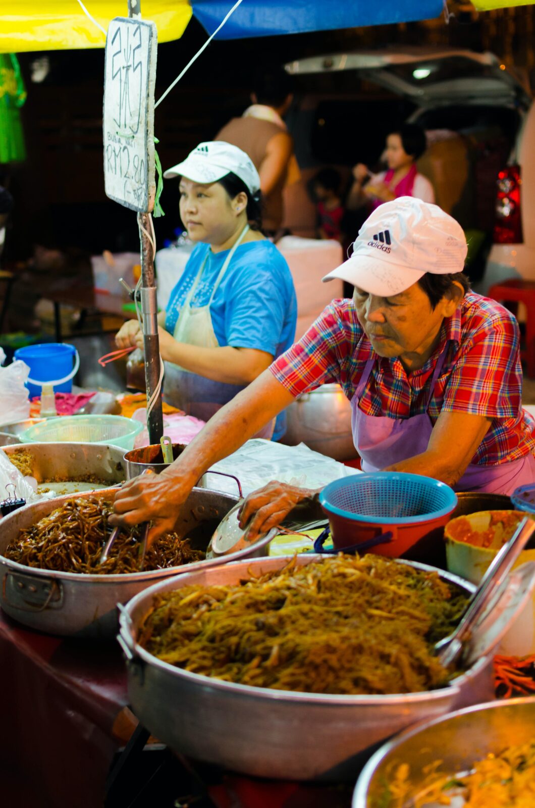 Malaysian Chinese Vendors at a roadside stall preparing food to be packed.