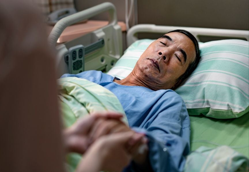An Asian Middle Aged Man Lying On A Hospital Bed