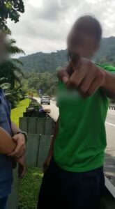 Man Pointing At Camera On A Highway In Malaysia, Face Blurred
