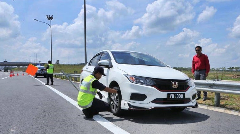 Plus Ronda Patrolmen Attending To A White Honda Car On The Roadside In Malaysia