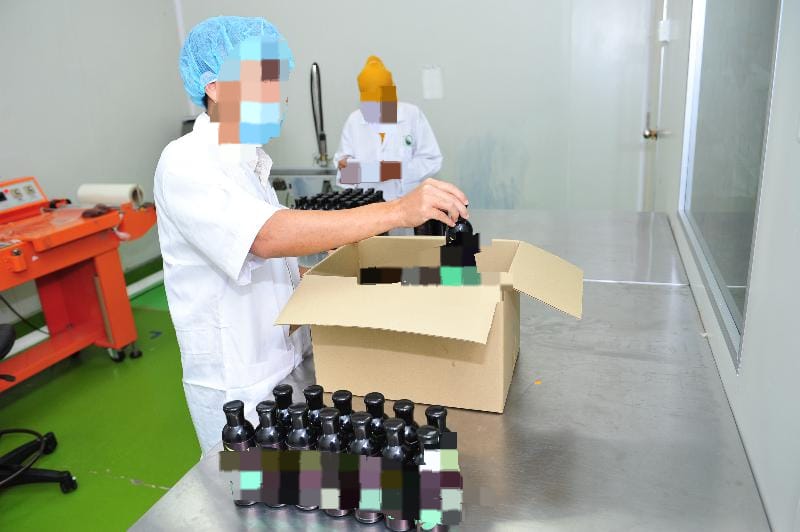 A Worker Packing Bottles In A Factory