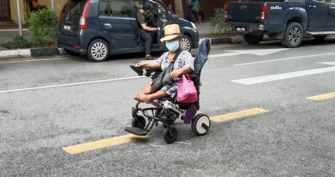 A homeless man with dwarfism on a wheelchair