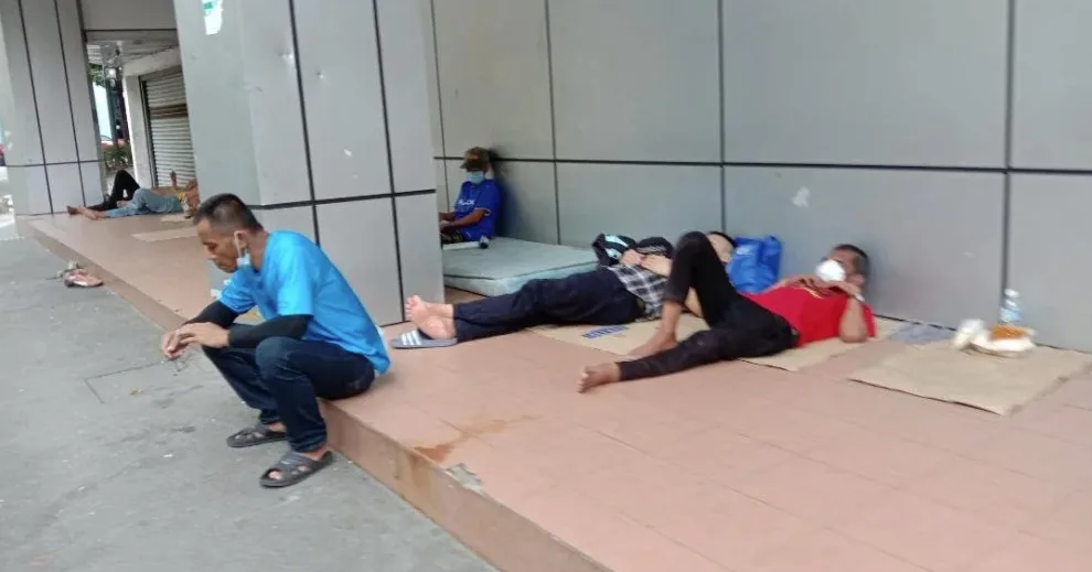 homeless men sleeping on cardboard